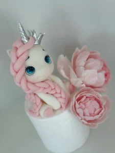 punutud patsiga ükssarvik ja kaks roosat suhkrulille